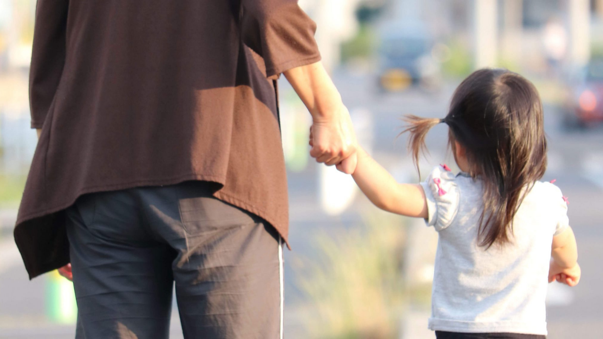 Adult and child holding hands