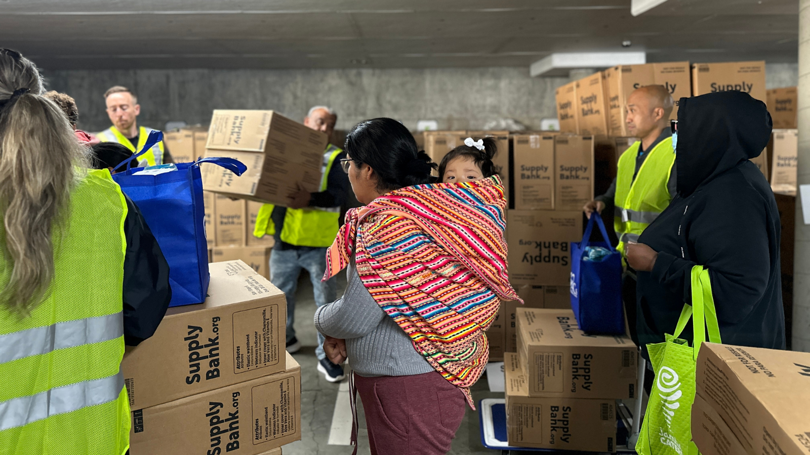 Families receiving cases of diapers from volunteers